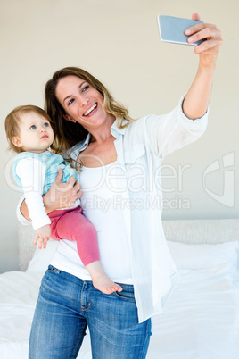 Smiling woman taking a selfie with her baby