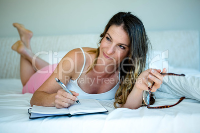 smiling woman with glasses writing in a book