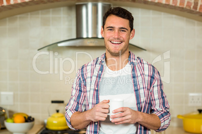 Portrait of young man holding a cup of coffee