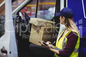 Delivery driver checking his list on clipboard