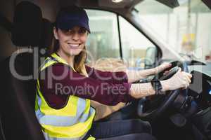 Delivery driver driving van with parcels on seat