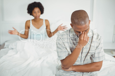 Upset man sitting on bed after argument