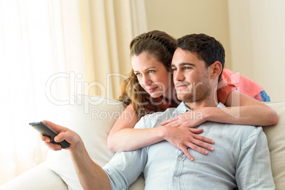 Young couple watching television together on sofa