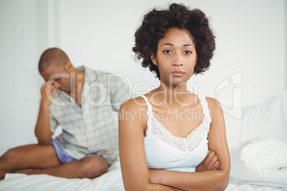 Upset woman sitting on bed after argument