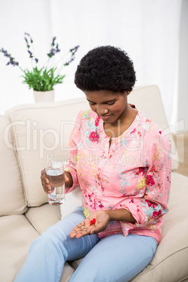 Pregnant woman holding pills and glass of water