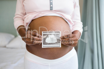 Pregnant woman holding ultrasound scan