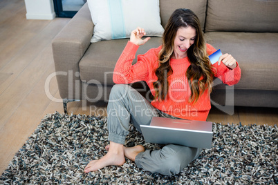 smiling woman on her laptop with credit card