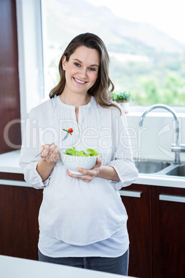 Pregnant woman eating salad