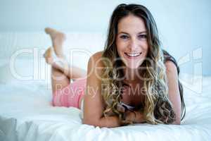 Smiling woman lying on her bed