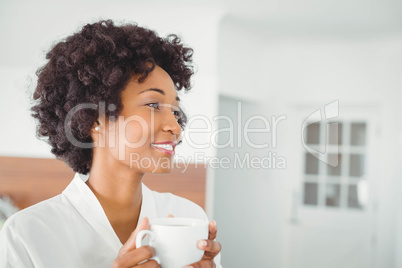 Pretty woman in bath robe drinking coffee