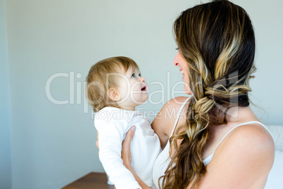 smiling brunette woman holding a happy baby