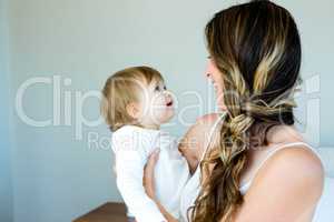 smiling brunette woman holding a happy baby