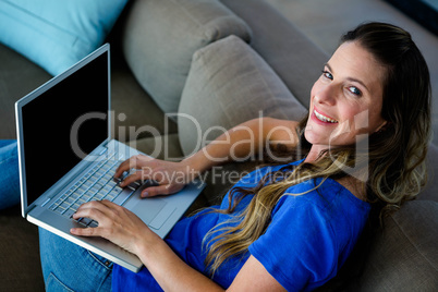 smiling woman typing on her laptop