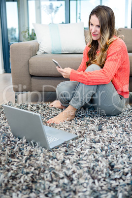 smiling woman on her laptop and mobile phone