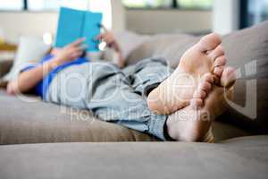 woman lying on the couch reading a book