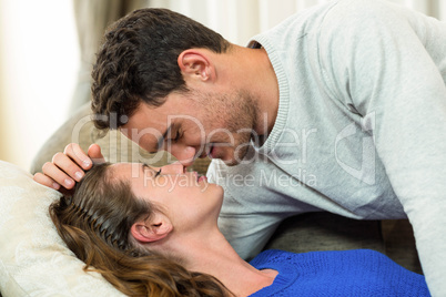 Young couple about to kiss on sofa