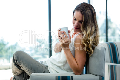 smiling woman sipping a cup of coffee