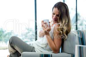 smiling woman sipping a cup of coffee