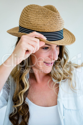woman wearing a straw fedora peering away