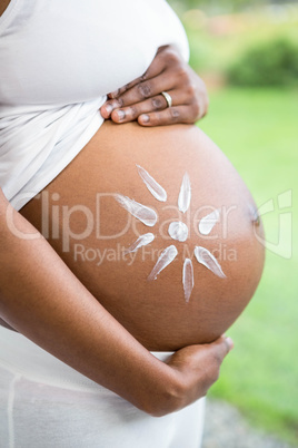 Pregnant woman applying cream on her belly