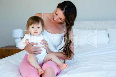smiling brunette woman holding a cute baby