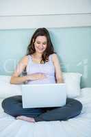 Pregnant woman using her laptop