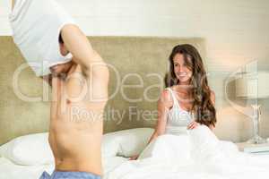 Man removing his vest in front of woman