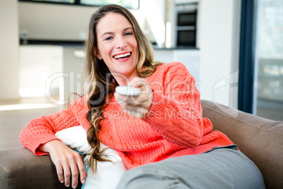 woman holding a remote control and smiling