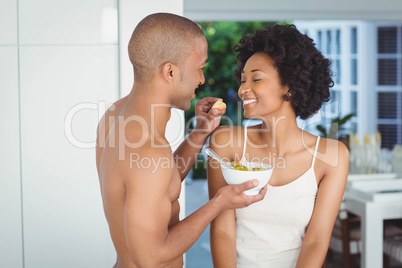 Happy couple eating breakfast in the kitchen