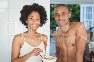 Happy couple eating breakfast in the kitchen