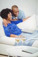 Happy couple on the sofa using laptop