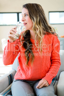 distracted woman drinking a glass of water