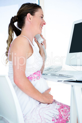 smiling pregnant businesswoman on the phone