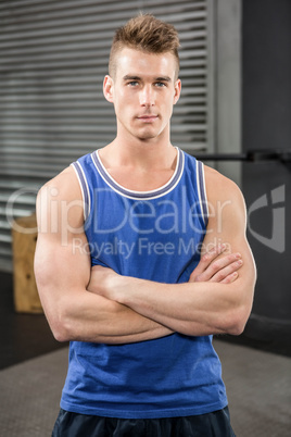 Muscular man standing with arms crossed