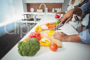 Mid section of couple preparing vegetables