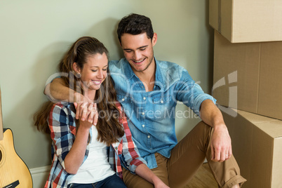 Young couple sitting together on the floor and smiling