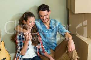 Young couple sitting together on the floor and smiling