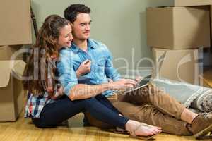 Young woman sitting on floor and using laptop