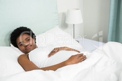 Pregnant woman resting on bed