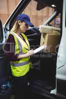Delivery driver checking his list on clipboard