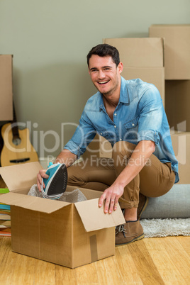 Young man unpacking carton boxes