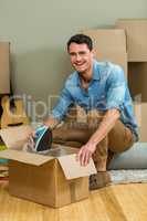 Young man unpacking carton boxes