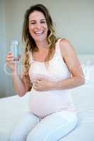 smiling pregnant woman drinking water