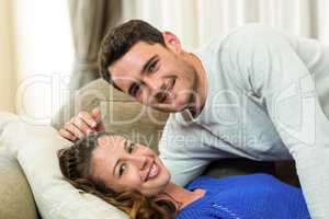 Portrait of young couple cuddling on sofa
