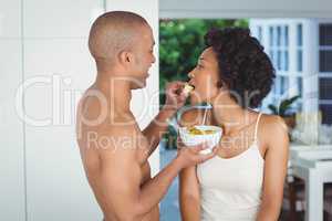 Happy couple eating breakfast in the kitchen