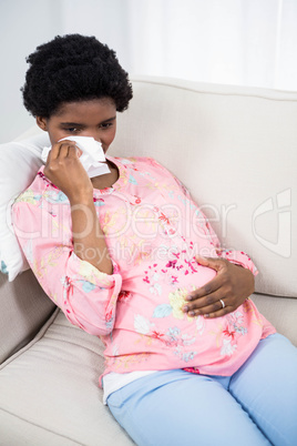 Sad pregnant woman relaxing on sofa