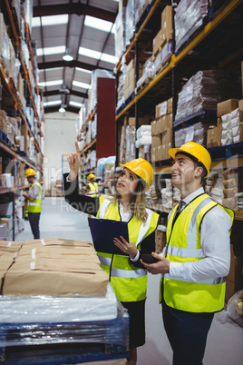 Warehouse managers looking at clipboard