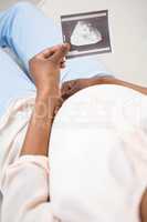 Pregnant woman holding ultrasound scan