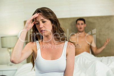 Upset couple sitting on bed