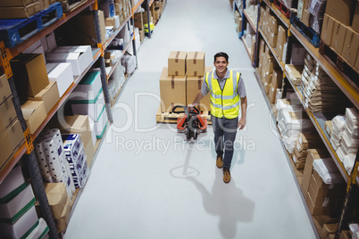 Worker pulling trolley with boxes